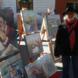 Piero Arcieri accanto ai suoi dipinti in mostra in via Sparano