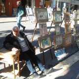 L'artista Michele Gurrado seduto accanto alle sue opere
