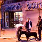 Alcuni tra gli ultimi giovani rimasti di fronte all'ultimo esercizio commerciale ancora aperto