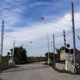 La strada si restringe dopo l'attraversamento di un passaggio a livello 