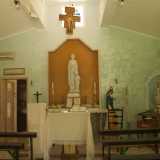 L'interno della cappella � piuttosto semplice, con l'altare avvolto da una parete turchese e puntellato da alcune statue votive