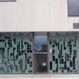 L�edificio presenta al piano terra un ampio spazio vuoto che fa da filtro tra esterno e interno circondato da una cancellata bronzea realizzata dal grande artista pugliese Raffaele Spizzico