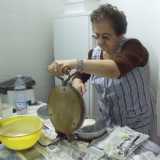 La signora Franca pone la pastella sulla piastra