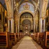 ... ci ritroviamo in un ambiente a tre navate riccamente decorato da marmi e stucchi. L�impianto � di ispirazione romanica, con uno schema longitudinale a croce latina e coro a gradoni...
