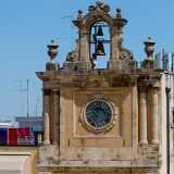 Completamente ristrutturata nell�800, si presenta distinta in tre livelli sovrastati da un arco campanario abbellito da due vasi etruschi. Il terzo piano accoglie due coppie di colonne tuscaniche e il quadrante di colore azzurrognolo
