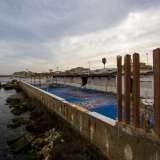 Sul retro dello stabile balza all'occhio la terrazza con vista sull'Adriatico, ormai spoglia, invasa dai detriti e con al centro lo scheletro di un vecchio gazebo