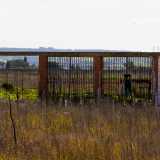 ...la cui entrata principale � segnata da tre ampi varchi chiusi da un�inferriata arrugginita e da grate pericolanti, dalle quali si scorge un campo infestato da rovi e sterpi