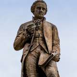 Quel che � certo � che ora Piccinni appare con una mano semichiusa che non contiene nulla. A dirla tutta pare che il compositore sia nell�atto di esclamare un sonoro �Cə u�?�. Riferito a chi, lo lasciamo all�immaginazione dei baresi
