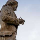 In realt�, ponendosi sul profilo destro di Piccinni e zoomando notevolmente sulla statua, � possibile notare un pezzo rimanente della penna, che quindi pi� che sparita appare spezzata