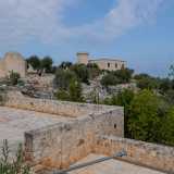 Ritornando sui nostri passi e proseguendo oltre l�entrata, il perimetrale lascia spazio a una recinzione pi� bassa. Qui sono anche presenti due piccole balconate in pietra che si affacciano su un vasto giardino. Tutta la struttura � infatti circondata da un ettaro di terra dove dominano ulivi, fichi d�india e cycas
