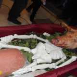 Tra le gambe dello scheletro c'� un grande pezzo di mortadella e sopra il collo spunta la testa di un maiale vero