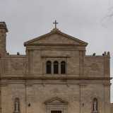 Davanti a noi si profila la candida facciata della chiesa dai tratti neoclassici scandita in due parti