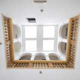 Giunti al primo livello svoltiamo a destra attraversando uno stretto corridoio e approdiamo in un ampio e alto spazio chiuso da un soffitto con quattro lucernari moderni