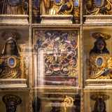 ...che comprende una teca dorata scandita in nove riquadri che contengono resti di santi. Ai busti neri con vesti d�oro di Olaro, Pio e Callisto seguono quelli di Lucia, Costanza, Cristoforo, Modesto e Carlo Borromeo...