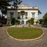 Ed eccoci al cospetto della villa, che si presenta con una bianca facciata palladiana, ispirata cio� alle opere del celebre architetto rinascimentale. Si sviluppa su un piano principale e uno seminterrato ed caratterizzata da elementi classicheggianti...