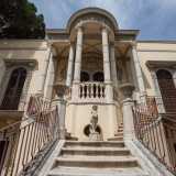 ...si divide in due scale separate e termina in un portico segnato da una notevole estroflessione circolare. Sorretta da colonne, rinvia ad architetture ellenistiche come i ninfei di Villa Adriana a Tivoli
