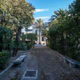 Superiamo cos� il cancello rosso per entrare nel giardino. Percorriamo il viale puntellato da alberi, siepi ben curate e panchine in pietra vegliate da antichi lampioncini