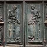 ...mentre al centro due scheletri speculari reggono delle pergamene, ricordando che davanti alla morte siamo tutti uguali a prescindere dal nostro ceto sociale