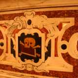 Oltre questa lastra � presente un parapetto in marmo policromo con raffigurazioni di teschi ocra su sfondo nero che delimitano la zona occupata dall�elegante altare