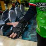 ...impugna la palla con un guanto utile a far aderire meglio le tre dita all�interno dei fori della boccia di colore giallo
