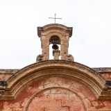 Pi� in alto un finestrone ornato da un doppio frontone ad arco introduce a un piccolo campanile
