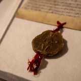 Al suddetto atto � legato con un nastro rosso lo stemma ufficiale reale in cera d�api, sul quale si vede l�imperatore che stringe fra le mani un globo e uno scettro: i simboli del sacro romano impero