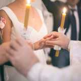 Il sacerdote scambia gli anelli agli sposi incrociandoli per tre volte mentre recita la formula di rito