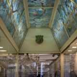 Percorriamo un lungo corridoio sotto un soffitto a mosaico azzurro e verde...