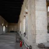 Attraverso una porta in legno si passa dall'esaforato al matroneo sinistro della Basilica: si notano un carrellino e una fila di armadietti bianchi posizionati sulla parete sinistra. Il matroneo era stato concepito per ospitare le donne durante le funzioni religiose