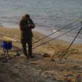 Un pescatore impegnato a montare le sue canne da pesca