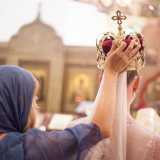 Una testimone aiuta la sposa a sorreggere l'imponente corona