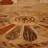 E� arrivato il tempo di andare via, ma mentre la penombra della luce del tramonto ricopre lentamente la navata centrale, il nostro sguardo cade sul mosaico pavimentale al centro della chiesa