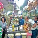 All'interno del locale moltissimi clienti fanno la fila per comprare leccornie di ogni genere sotto lo sguardo di Vito, uno dei proprietari, qui immortalato in primo piano a sinistra