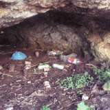 Interno di una grotta a cala Colombo, piena di rifiuti