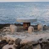Un tavolo con delle sedie in cemento posto a ridosso del mare, a San Domenico