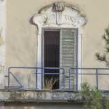 Una delle finestre dell'edificio: i vetri sono rotti e le persiane lesionate