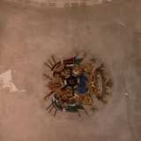 Il simbolo patrizio si ripropone sotto l'arco che incontriamo poco dopo aver varcato l'entrata principale. Si tratta di un affresco impreziosito da un lampadario: consiste essenzialmente in tre palme intrecciate attorno a un elmo su sfondo azzurro, dettagli che suggeriscono l'abitudine dei Palmieri a compiere pellegrinaggi
