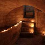 Ci guardiamo intorno: siamo in un vano di cinque metri per tre, circondato da muri in tufo e malta e sormontato da un soffitto a volta alto un paio di metri