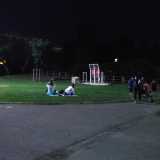 Sulla sinistra un gruppo di ragazze distese sui tappetini si gode la tranquillit� del parco di sera