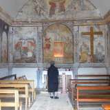 Una fedele in preghiera davanti all'affresco dell'Annunciazione, all'interno della chiesetta dell'Annunziata