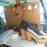 Un paio di scarpe che una cliente ha appena portato e alcuni ferri del mestiere