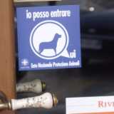 Adesivo dell'Enpa esposto sulla porta di un locale pubblico