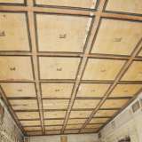 L�ampio salone con soffitto ligneo a cassettoni e formelle decorative con volti umani lungo le mura