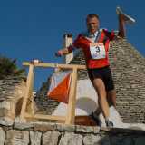 Un atleta di orienteering raggiunge un punto di controllo durante una corsa nel centro storico di Alberobello