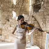 Nella torre echeggiano le note di un violino suonato da una giovane artista