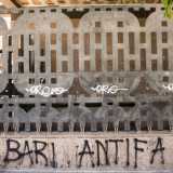 Un particolare della cancellata imbrattata da scritte di natura politica