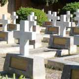 Ai nostri lati osserviamo in silenzio decine e decine di croci bianche disposte per file: ciascuna di esse ha una targa in bronzo che indica grado militare, nome, cognome, data di nascita e di morte del caduto