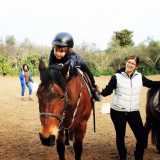 L�istruttrice fa fermare i due bambini per far effettuare loro alcune azioni come accarezzare le orecchie del cavallo o sdraiarsi sul suo dorso