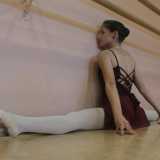 Ballerina durante un esercizio di stretching per l'apertura delle gambe