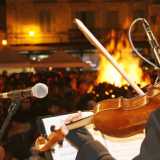 Violinista che suona una melodia popolare davanti al fuoco